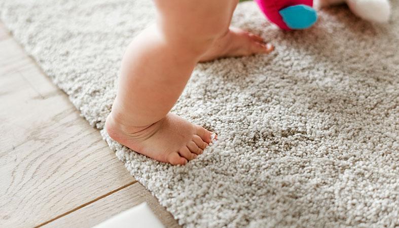 a close up photo of the carpet with a baby foot on it
